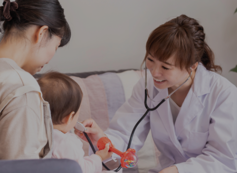 医療スタッフが子どもに聴診器を使った健康診断を行っている場面